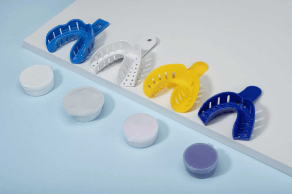 Impression trays and putties of different at-home teeth straightening brands.