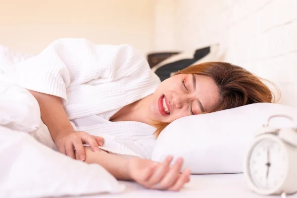 An image of a woman grinding her teeth while sleeping